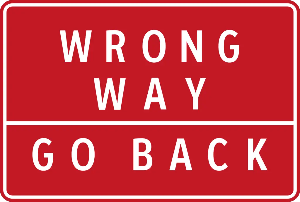 A road sign that says "Wrong Way, Go Back".