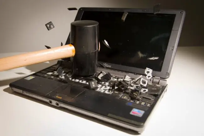 A laptop smashed with a hammer