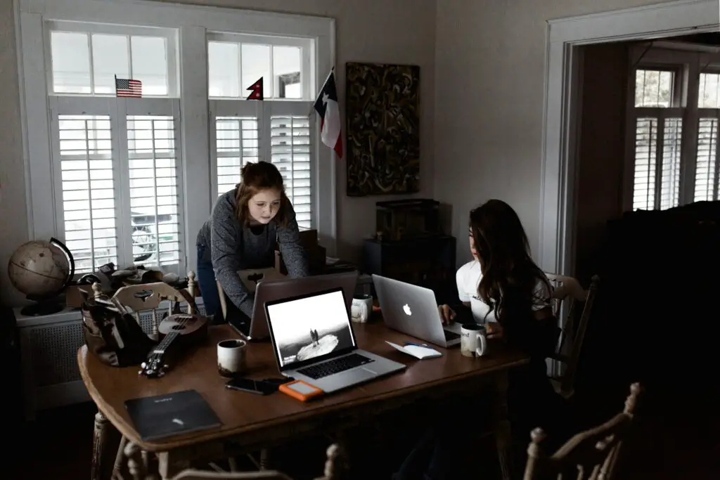 two girls using laptops