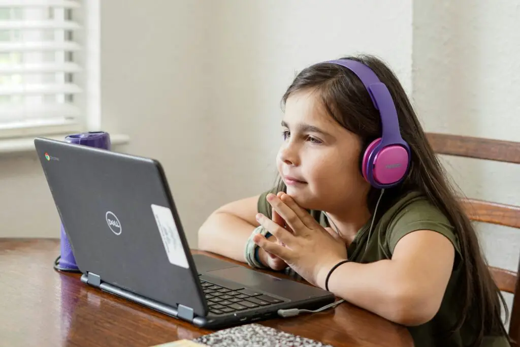 girl wearing headphones looking at laptop